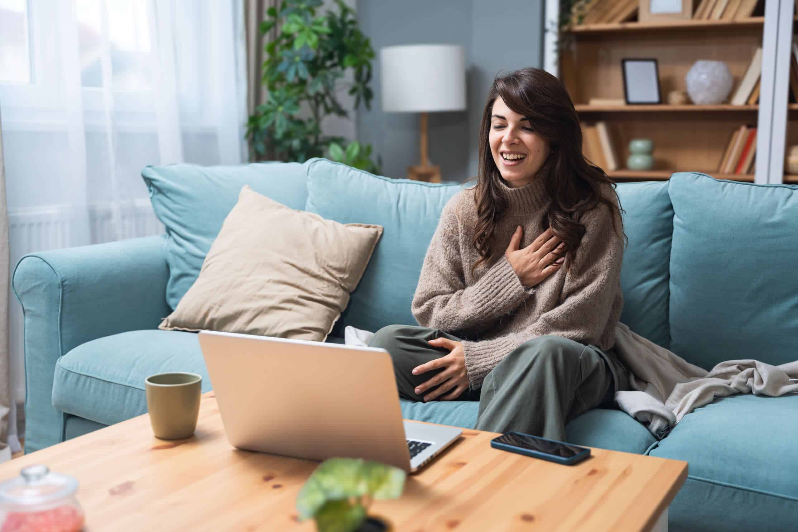 Woman smiling during an online somatic therapy session for polyvagal nervous system regulation