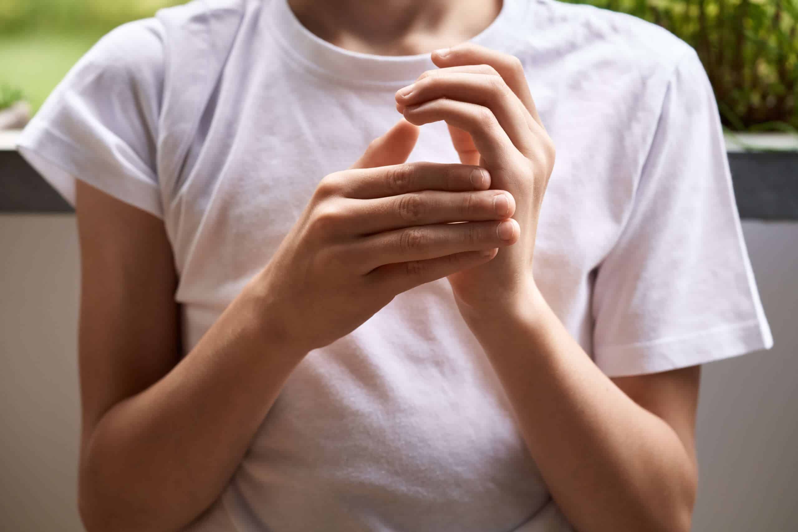 Close-up of hands demonstrating EFT tapping technique for stress relief