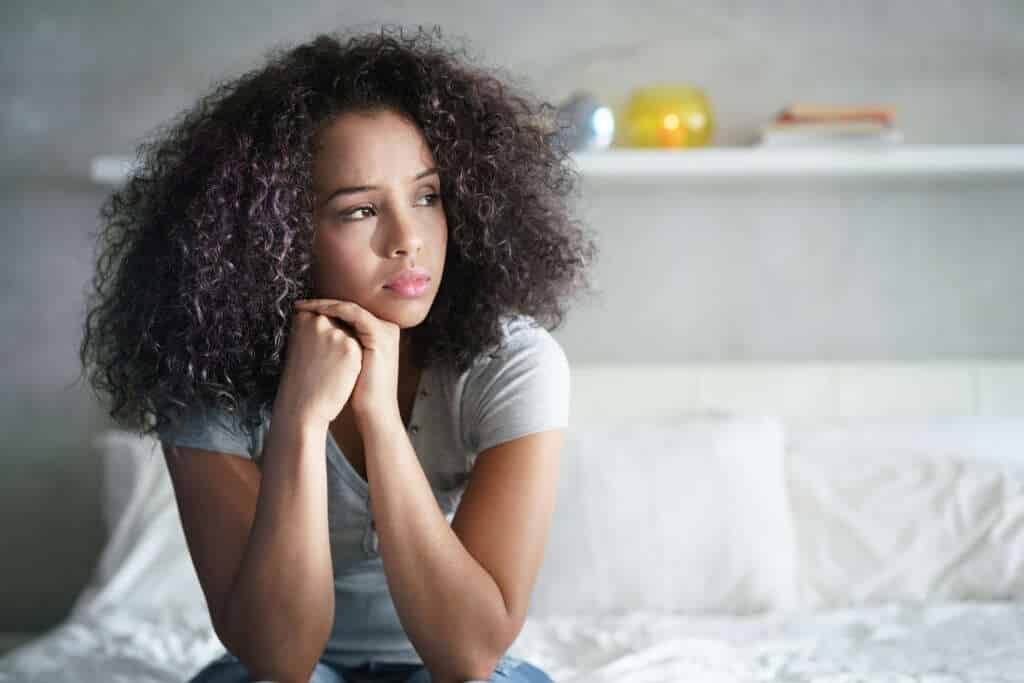 Woman resting her head on her hand looking tired from hidden physiological stress