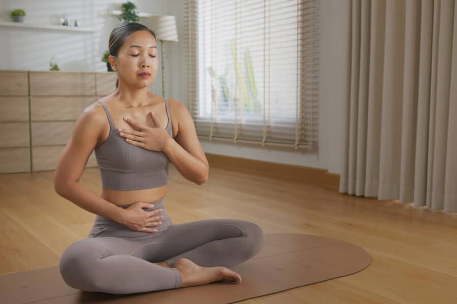 Calm asian woman yoga studio practice sound healing with tibetan singing bowl inspired breathwork meditation, mindful self care mat with soft light and peaceful Sound Healing Tibetan singing bowl